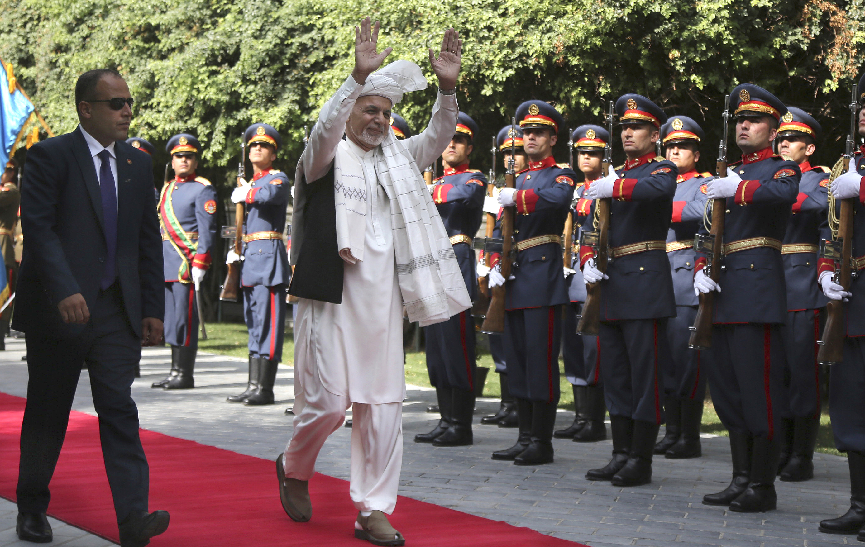 Afghanistan's President Ashraf Ghani, center, greets as he arrives to offer Eid al-Adha prayers at the presidential palace in Kabul, Afghanistan, Sunday, Aug. 11, 2019.