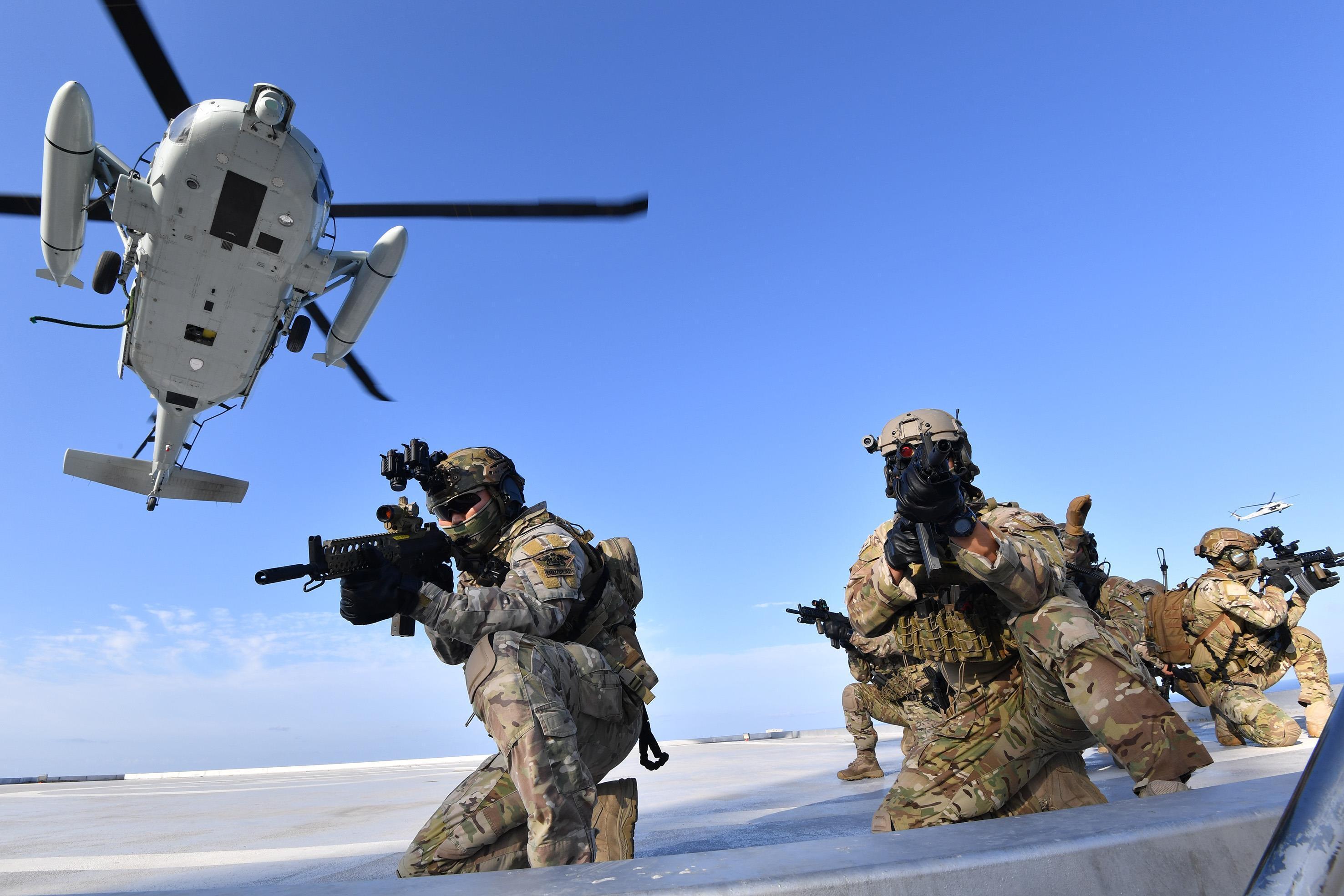 Members of the South Korean Navy's special forces aim their weapons after landing from UH-60 helicopter during a drill on the islets called Dokdo