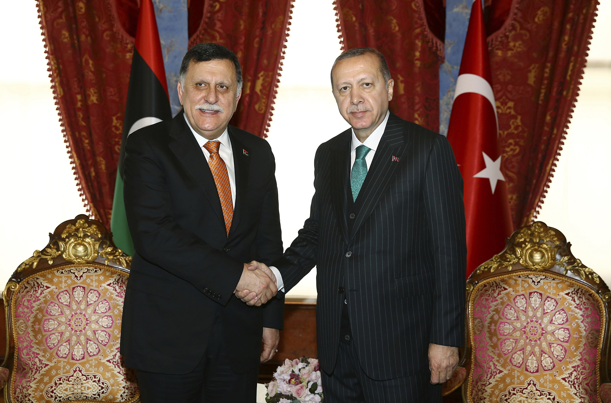 In this Feb. 26, 2018, file photo, Turkish President Recep Tayyip Erdogan, right, shakes hands with Fayez al-Sarraj, the chairman of the Libyan Presidential Council, shortly before departing for a five-day African tour, in Istanbul.