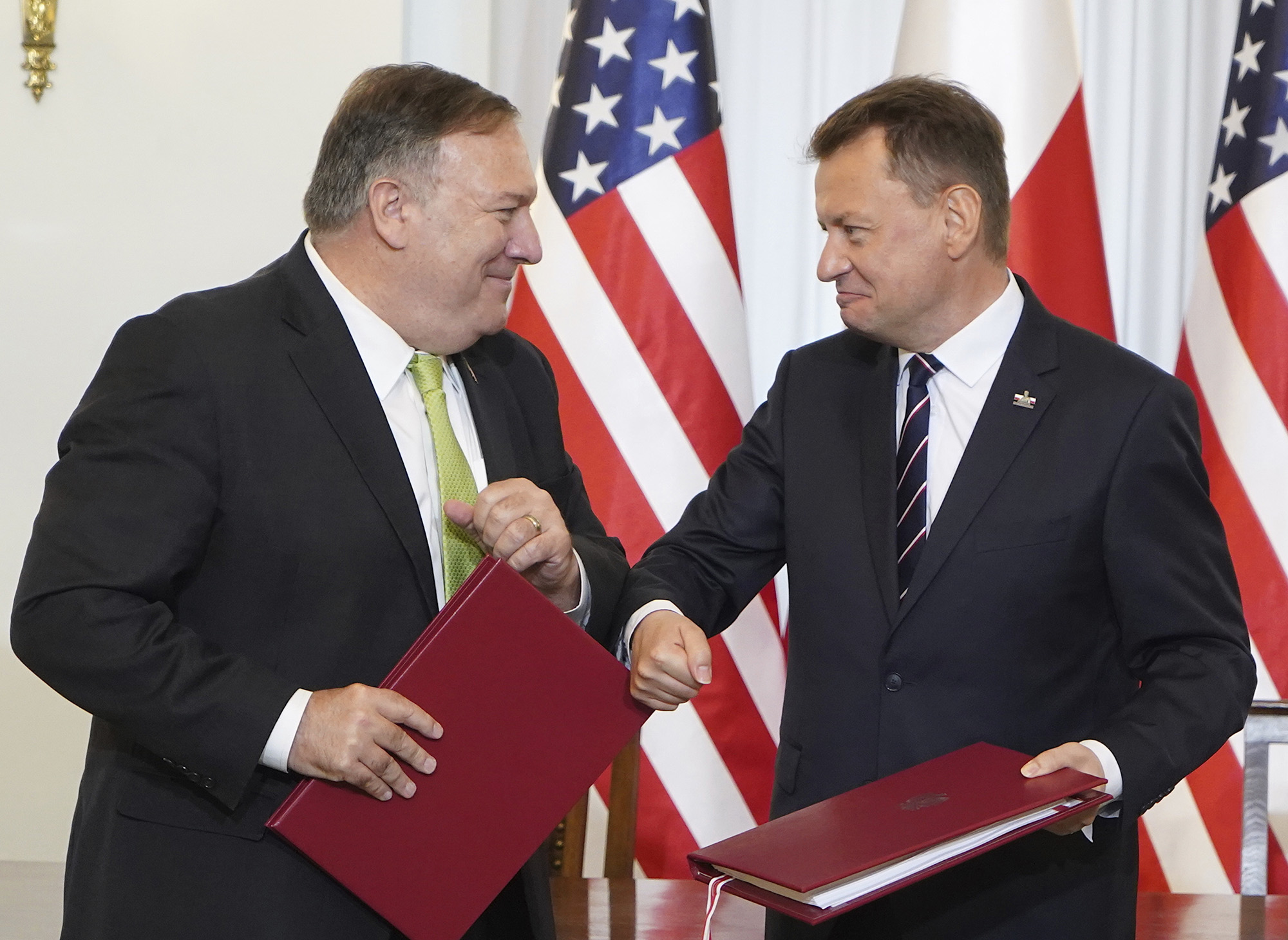 U.S. Secretary of State Mike Pompeo, left, and Poland's Minister of Defence Mariusz Blaszczak greet each other after signing the US-Poland Enhanced Defence Cooperation Agreement in the Presidential Palace in Warsaw, Poland, Saturday Aug. 15, 2020.