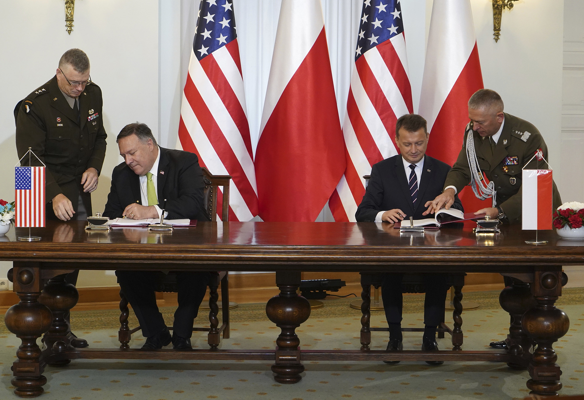 U.S. Secretary of State Mike Pompeo, left, and Poland's Minister of Defence Mariusz Blaszczak sign the U.S.-Poland Enhanced Defence Cooperation Agreement in the Presidential Palace in Warsaw, Poland, Saturday Aug. 15, 2020.