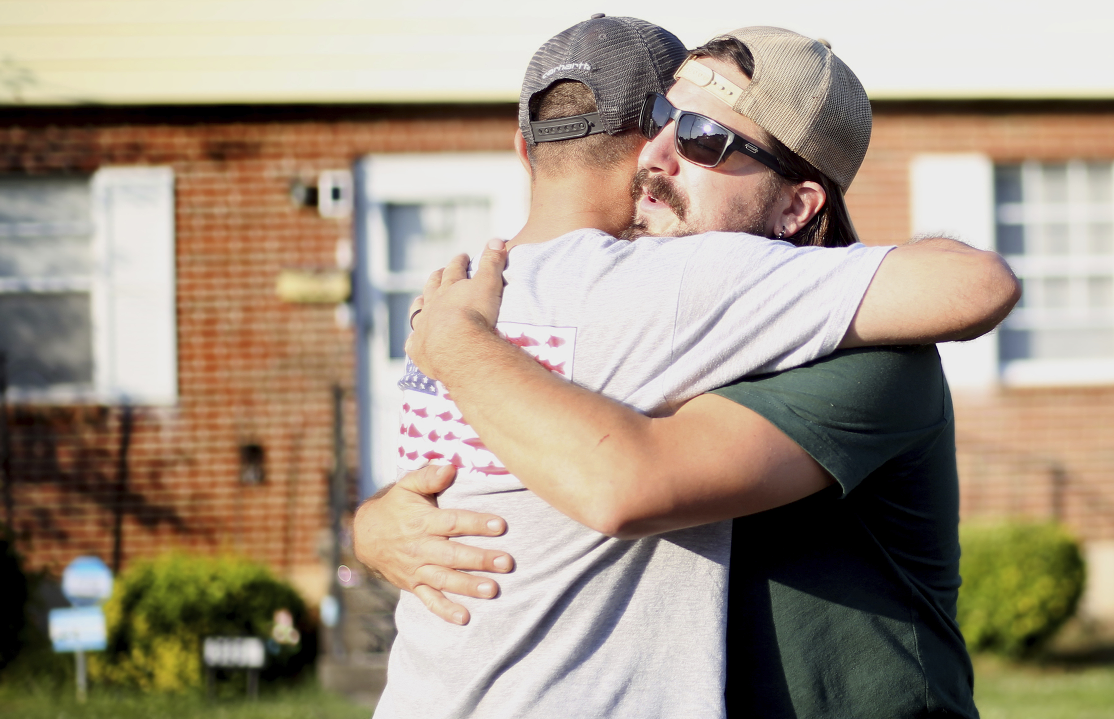 Tashmorad Qara, left, and Andreas Panagore share a moment after catching up over a traditional Afghan meal, prepared by Qara, on May, 17, 2023, in Roanoke, Va.