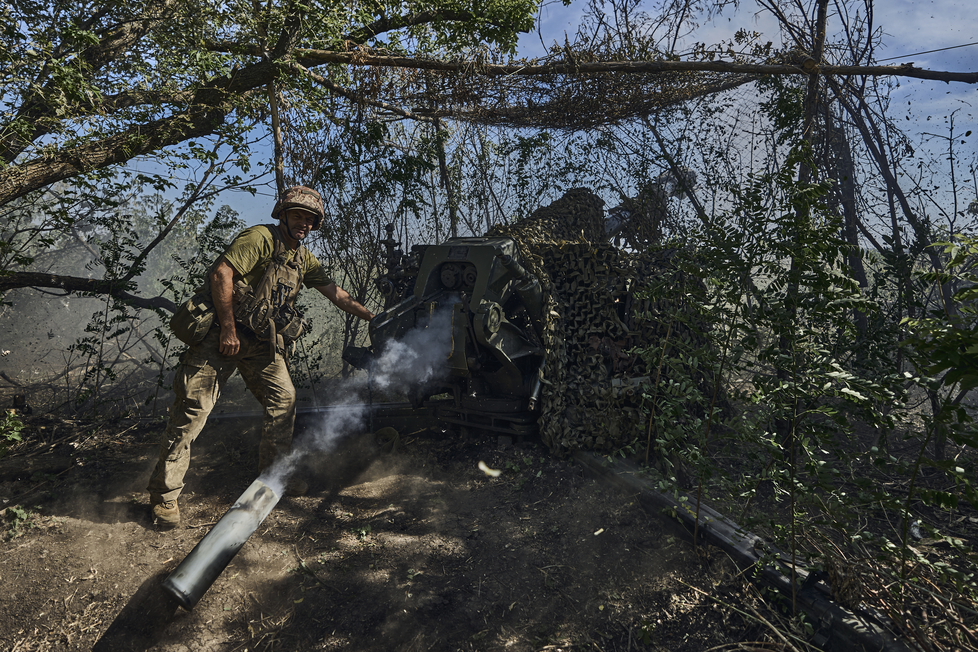 A Ukrainian serviceman of the 31 Brigade fires a D-30 cannon towards Russian positions at the front line in Donetsk region, Ukraine, Wednesday, Aug. 9, 2023.